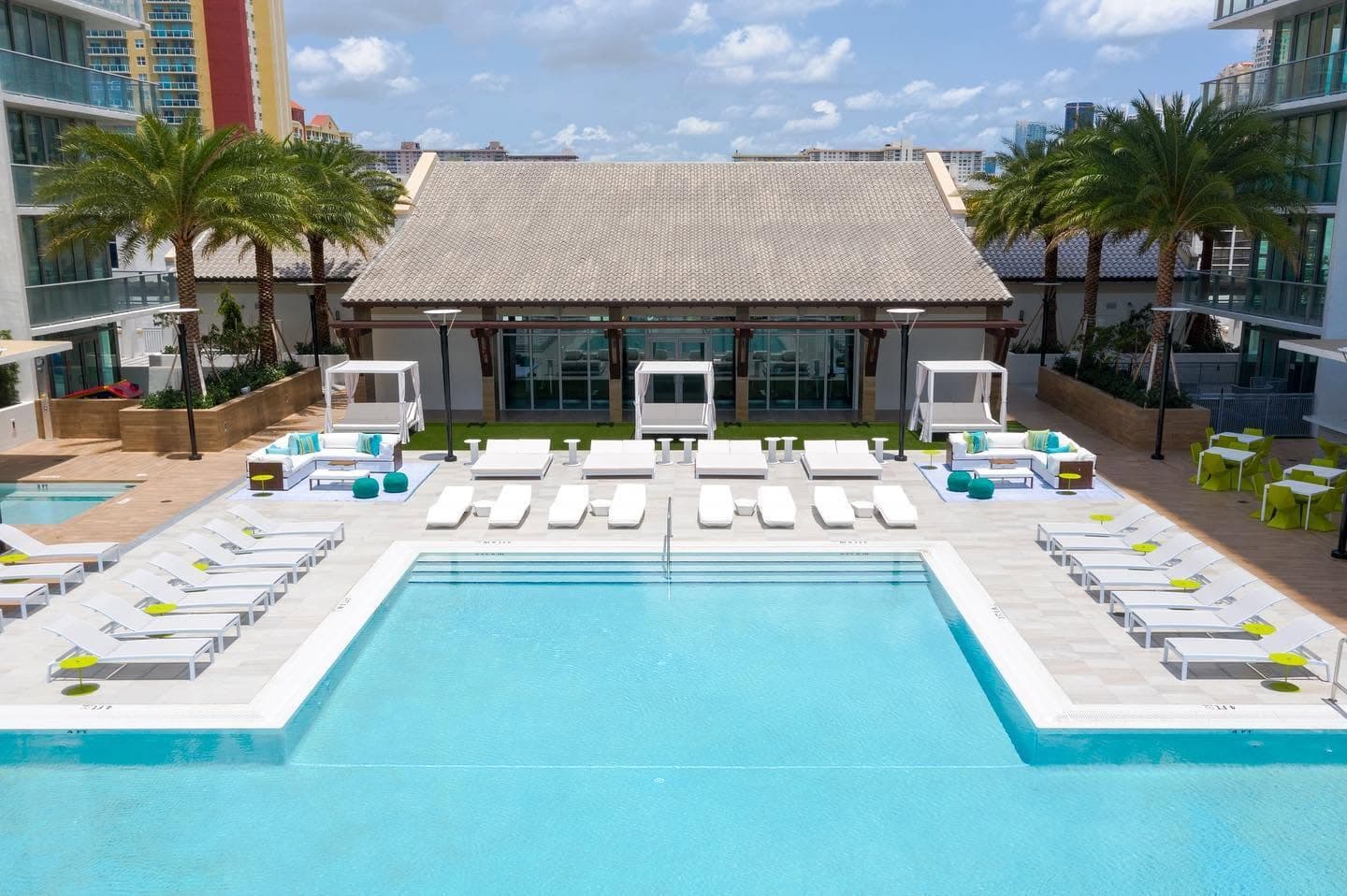 Resort-style swimming pool with cabanas and lounge chairs